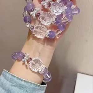 Detailaufnahme eines Amethyst-Perlenarmbands mit dekorativer Bergkristall-Blüte