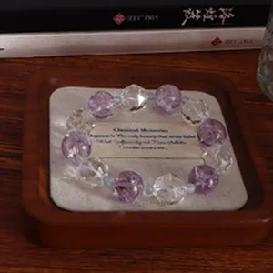 Detailansicht eines 14-mm-Armbands aus natürlichem Amethyst auf einem Holztablett