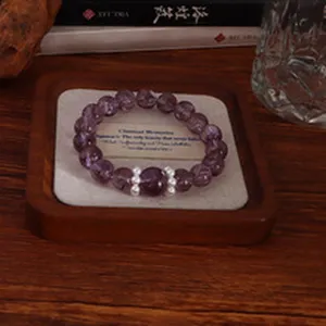 Makroansicht von 14 mm Natur-Amethyst-Perlen auf einem klassischen Holz-Display-Tablett.