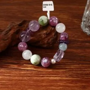 Detail eines handgefertigten Naturamethyst-Armbands mit 14mm lila, weißen und grünen Steinen