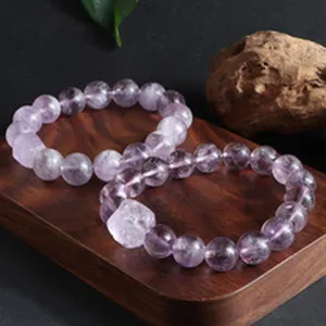 Nahaufnahme von 14mm Naturamethyst-Perlenarmbändern auf einem Holzsockel