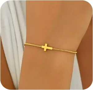 Nahaufnahme eines minimalistischen, vergoldeten Armbands mit horizontalem Kreuz