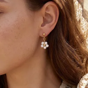 Elegante goldene Blumenohrringe mit weißen Perlen, ideal für Hochzeiten oder Partys.
