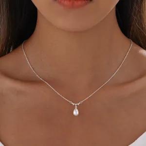 Nahaufnahme einer eleganten silbernen Halskette mit weißem Perlenanhänger in Tropfenform.