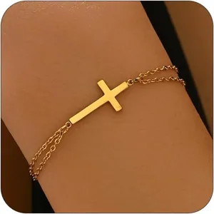 Detailansicht eines minimalistischen goldfarbenen Doppelkettenarmbands mit Kreuz