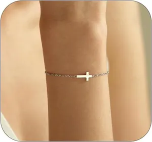 Detailansicht eines zarten Silberarmbands mit einem horizontalen Kreuzanhänger am Handgelenk