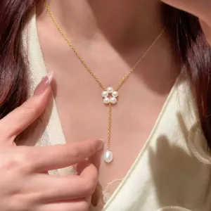 Elegante Perlenblumenhalskette mit goldener Quaste, am Hals eines Models gezeigt.