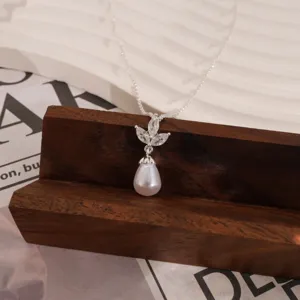 Elegantes Halskettendetail mit Tropfenperlenanhänger und blattförmigen Kristallakzenten