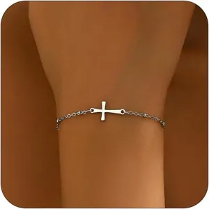 Detailansicht eines minimalistischen silbernen Armbands mit seitlichem Kreuz am Handgelenk