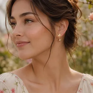 Detailansicht eleganter goldener Vintage Perlenohrringe an einem Model im Garten