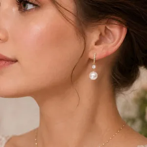 Detailansicht eines eleganten Perlenohrrings mit Steinchenbesatz an einem Model