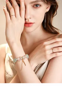 Nahaufnahme eines eleganten Armbands aus weißem Kristall und grünem Fluorit am Handgelenk