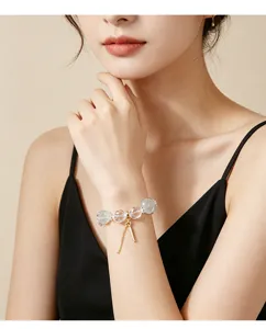 Nahaufnahme eines minimalistischen Kristallarmbands mit grünem Fluorit am Handgelenk.