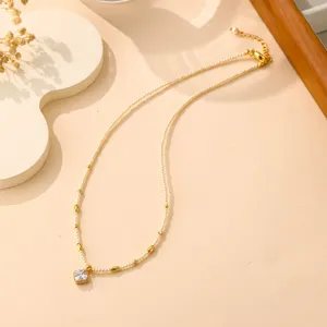Detailansicht einer eleganten Perlenkette mit Goldperlen und Zirkonia-Anhänger