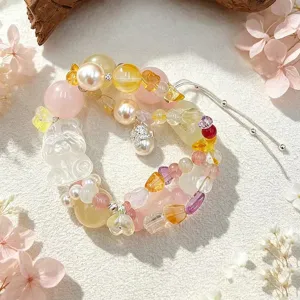 Nahaufnahme eines bunten Naturkristall-Armbands mit geschnitztem Fuchshänger und Perle.