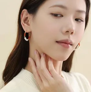 Detailansicht eines asiatischen Models mit eleganten Creolen aus Naturperlen und Roter Achat