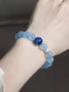 Detailansicht eines Aquamarin-Kristallarmbands am Handgelenk mit Disthen-Akzent