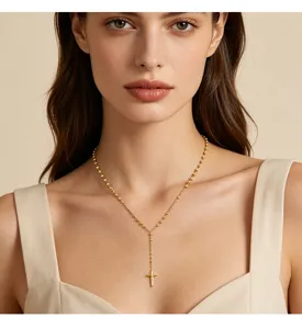 Detail einer eleganten goldenen Y-Halskette mit Kreuzanhänger an einem weiblichen Model