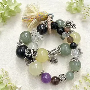 Detailansicht eines Edelstein-Armbands mit floralen Anhängern und Quaste