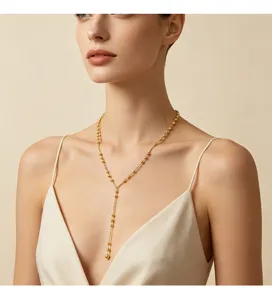 Detailaufnahme einer eleganten goldenen Y-Halskette mit zarten Perlen an einem Model