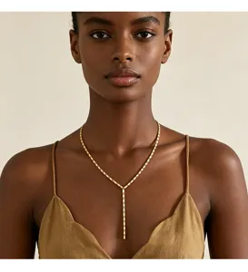 Nahaufnahme einer eleganten goldenen Y-Halskette an einem Modell im olivgrünen Top.