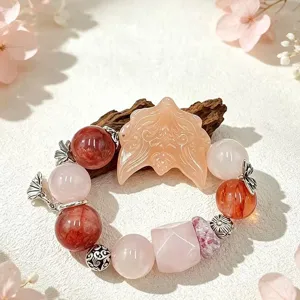 Detailaufnahme eines natürlichen Rosenquarz-Armbands mit Fuchskopf-Anhänger.