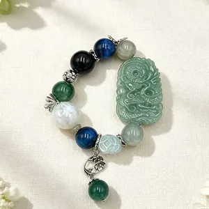 Detailansicht eines Armbands aus bunten Kristallperlen mit großem grünen Jadegeschnitz