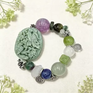 Detaillierte Makroansicht eines Kristallarmbands mit einem geschnitzten Jadeanhänger