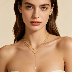Eleganter goldener Y-förmiger Tropfenanhänger mit Kristallen an einem Frauenmodell