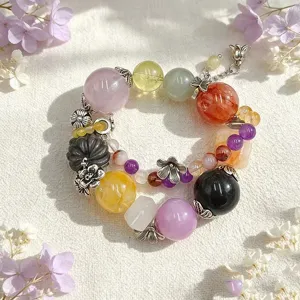 Detailansicht eines bunten Naturkristall-Armbands mit eleganten floralen Anhängern.