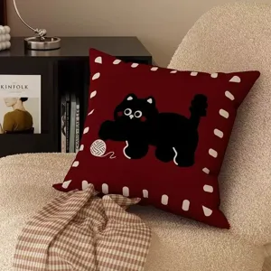 Cozy dark red throw pillow detail with cute black cat pattern, soft fabric and warm home decor.
