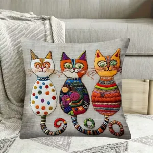 Vista detallada de la funda de cojín decorativa con coloridos motivos de gatos bordados.