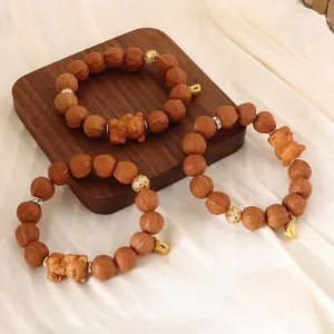 Handgefertigtes Holzperlenarmband mit niedlichem Bären-Anhänger und goldenen Details