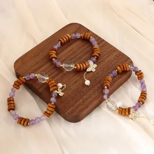 Elegantes Armband aus Amethyst und Sandelholz mit goldenem Schmetterlingsanhänger