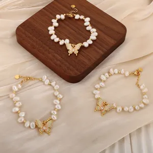 Detailaufnahme eleganter Naturperlenarmbänder mit farbenfrohen Schmetterlingsanhängern