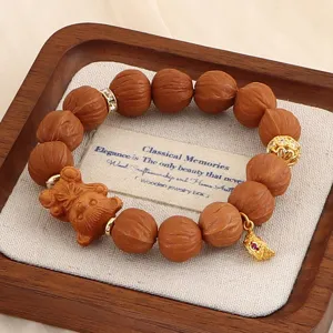 Detail eines Holzperlenarmbands mit geschnitztem Bärenanhänger und goldener Krone