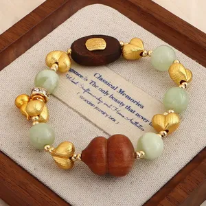 Makro-Detailansicht des Sandelholz-Armbands mit goldenen Herzperlen und grünem Jade-Stein