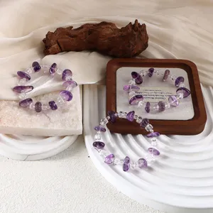 Detailansicht von Armbändern aus natürlichem Amethyst und klarem Quarz auf Requisiten.