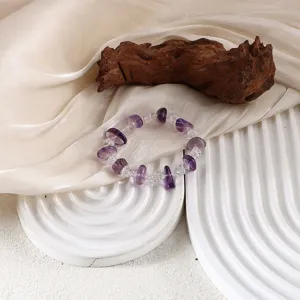 Nahaufnahme eines eleganten Armbands aus Amethyst und klarem Quarz auf ästhetischem Grund