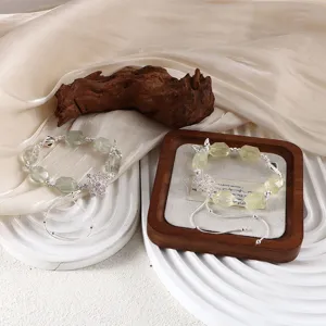 Detail von handgefertigten Perlenarmbändern mit rotierenden Schneeflocken-Anhängern.