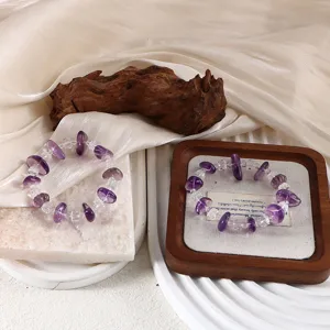 Detailansicht von Armbändern aus natürlichem Bolivien-Amethyst und Bergkristall auf Holztablett