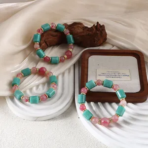 Detailansicht der Perlenarmbänder aus Amazonit und Sakura-Regenstein auf einem Holztablett