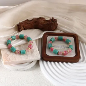 Natur-Amazonit und Kirschblüten-Achat Armband mit goldenen Abstandsperlen im Display.