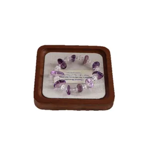 Armband aus natürlichem Bolivien-Amethyst und Bergkristall auf elegantem Holztablett
