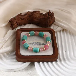 Natur-Amazonit- und Kirschblütenstein-Perlenarmband auf einem Holz-Display-Tablett