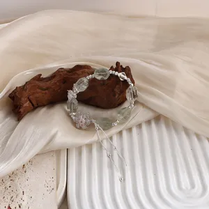 Detailansicht eines Kristallarmbands mit rosa Schneeflocke und silberner Quaste.