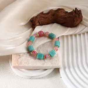 Detailansicht eines Amazonit-Armbands mit rosa Jaspisperlen auf Naturstein
