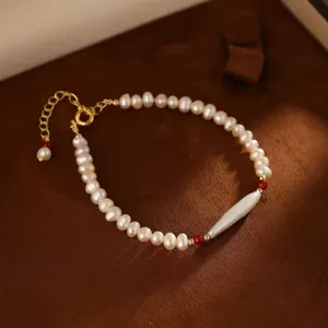 Nahaufnahme eines Naturperlenarmbands mit roten Achatperlen und einer langen Barockperle