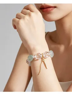 Naturkristall-Armband mit grünem Fluorit und Goldanhänger am Handgelenk des Models