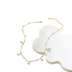 Minimalistische 14K vergoldete Halskette mit Glastropfenperlen auf weißem Tablett